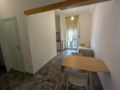 a living room with a wooden table and chairs at Isolina 63 in Rome