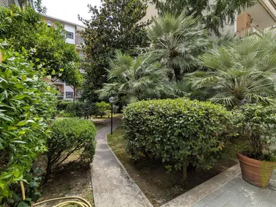 a garden with bushes and trees and a building at Isolina 63 in Rome