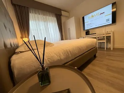 a hotel room with a bed and a table and a television at Rome Inn Vatican View Rooms in Rome