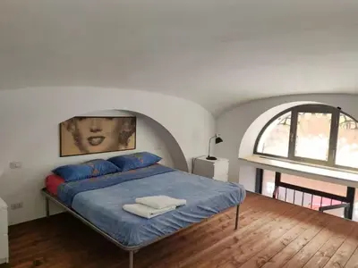 a bedroom with a bed with blue sheets and a window at Termini CARMELOFT in Rome
