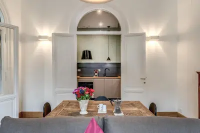 a dining room table with a vase of flowers on it at Corso charming suite in Rome
