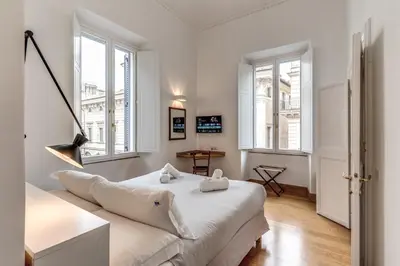 a living room with a white couch and windows at Corso charming suite in Rome