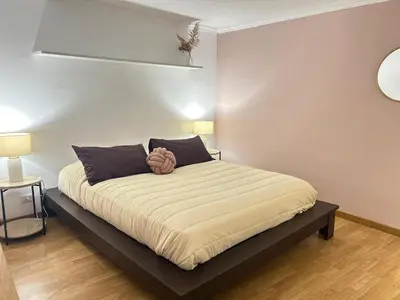 a large bed in a room with two lamps at Saint John House in Rome