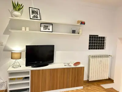 a living room with a flat screen tv on a cabinet at Saint John House in Rome