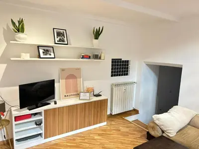 a living room with a flat screen tv on a stand at Saint John House in Rome