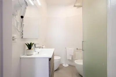 a white bathroom with a sink and a toilet at Barchetta Loft in Rome