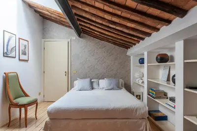 a bedroom with a bed and a green chair at White Room with bathroom and Shared Terrace in Rome