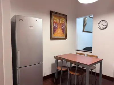 a kitchen with a table and a refrigerator at Sanniti House in Rome
