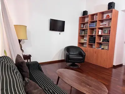 a living room with a couch and a chair and a book shelf at Sanniti House in Rome