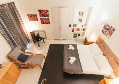 a living room with a bed and a table and chairs at Delizioso loft vicino Piazza del Popolo in Rome