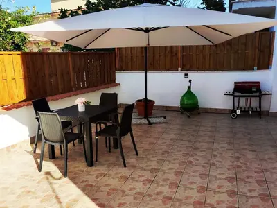 a patio with a table and chairs and an umbrella at casetta romana in Rome