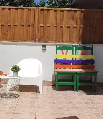 a colorful bench sitting next to a white wall at casetta romana in Rome