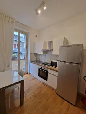 a kitchen with a stainless steel refrigerator and a table at Casa Claudia in Rome