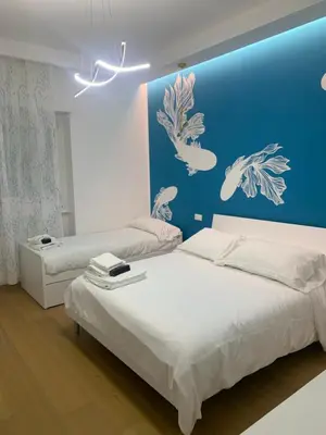 a bedroom with two beds and a blue wall at Roma Tiburtina - Elementcity Suites in Rome