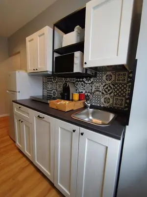a kitchen with white cabinets and a sink at Hub in R'home in Rome