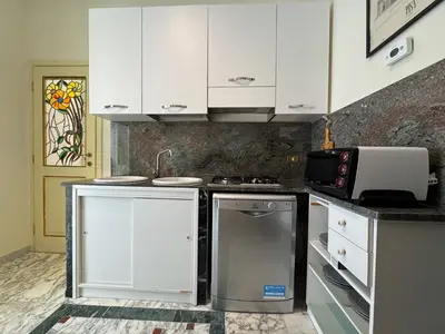 a kitchen with white cabinets and a sink and a microwave at Big bright Flat - Vatican Foro Italico in Rome