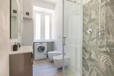 a bathroom with a toilet and a washing machine at Domus Ponte Lungo in Rome