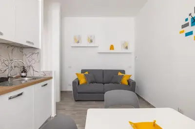 a kitchen and a living room with a couch at Domus Ponte Lungo in Rome