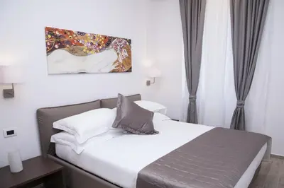 a bedroom with a bed and a painting on the wall at Maison Maneli in Rome