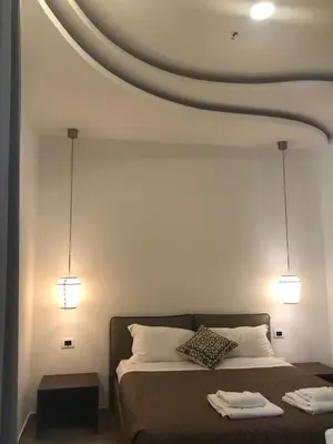 a bedroom with a bed with two lights above it at Maison Maneli in Rome