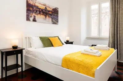 a bathroom with a white sink and a door at Fernando’s Apartment in Rome