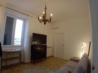 a living room with a couch and a chandelier at Casa di Andrea 2 in San Pietro in Rome