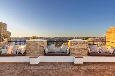 a row of pillows sitting on a patio at Torre della Luna Roma Lusso, Privacy e Piscina con Vista su San Pietro in Rome