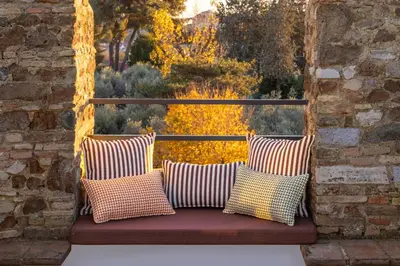a bench with three pillows sitting on a balcony at Torre della Luna Roma Lusso, Privacy e Piscina con Vista su San Pietro in Rome