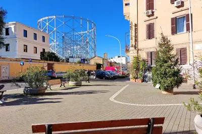 a bench on a street with a large metal structure at Gioia's Home in Rome