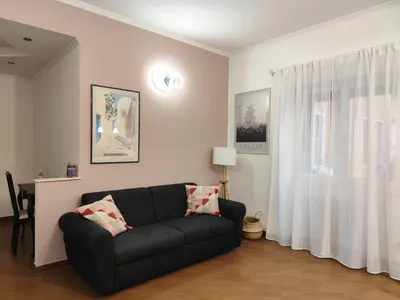 a living room with a black couch and a window at Next Stop St Peter - Apartment in Rome