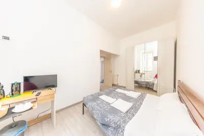 a bedroom with a bed and a desk and a television at San Pietro View Boutique Rooms in Rome