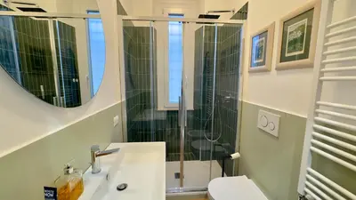 a bathroom with a sink and a mirror and a toilet at Elegant suite near the Vatican in Rome