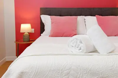 a bedroom with a white bed with pink pillows at 4BNB - Flaminio Modern Apartment in Rome