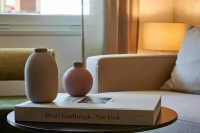 a book and two vases sitting on top of a table at Art Suite San Giovanni in Rome