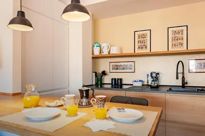 a kitchen with a table with two plates and orange juice at L'Attico di Katia in Rome