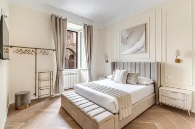 a white bedroom with a bed and a window at 3 minutes walk from Termini Station With Temple View in Rome