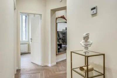 a hallway with a mirror and a vase on a glass table at 3 minutes walk from Termini Station With Temple View in Rome
