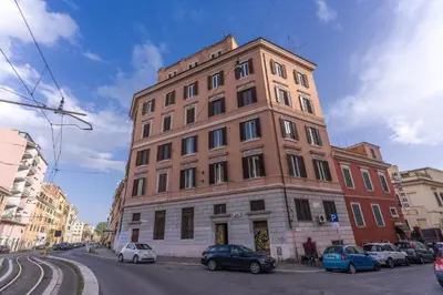 a tall brick building with cars parked in front of it at 3 minutes walk from Termini Station With Temple View in Rome