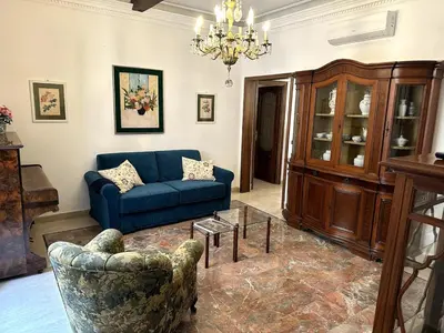 a living room with a blue couch and a chair at Borgo Pio Vatican in Rome