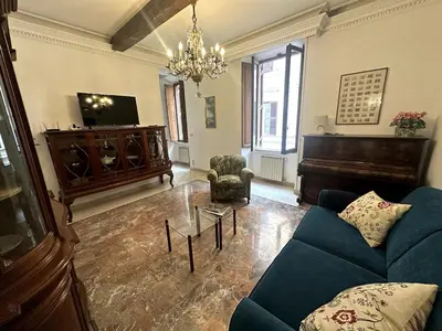a living room with a blue couch and a piano at Borgo Pio Vatican in Rome