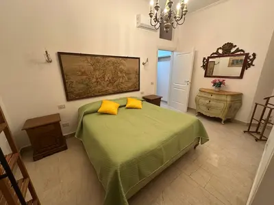 a bedroom with a green bed with two yellow pillows at Borgo Pio Vatican in Rome