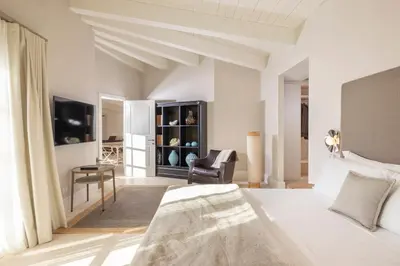a white bedroom with a bed and a chair at Exclusive Home with pool and iconic View on Saint Peter in Rome