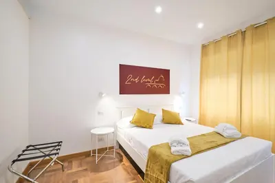 a bedroom with two beds with yellow pillows at 2ND Level in Rome