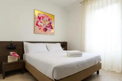 a bedroom with a large white bed and a window at Villa Aurora Rooms in Rome