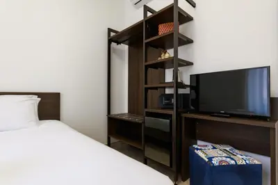 a bedroom with a bed and a flat screen tv at Villa Aurora Rooms in Rome