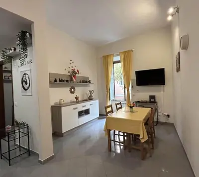 a living room with a table and a television at A Casa di Mario al Pigneto in Rome