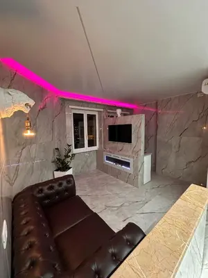 a living room with a leather couch and a tv at Gladiatrice Suite in Rome