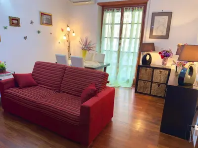 a living room with a red couch and a table at Mancinelli Rome Apartment in Rome