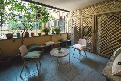 a living room with a table and chairs and a window at Habitat 42 Roman Stay in Rome