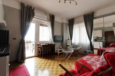 a living room with a red couch and a window at Le Note Di Angela in Rome